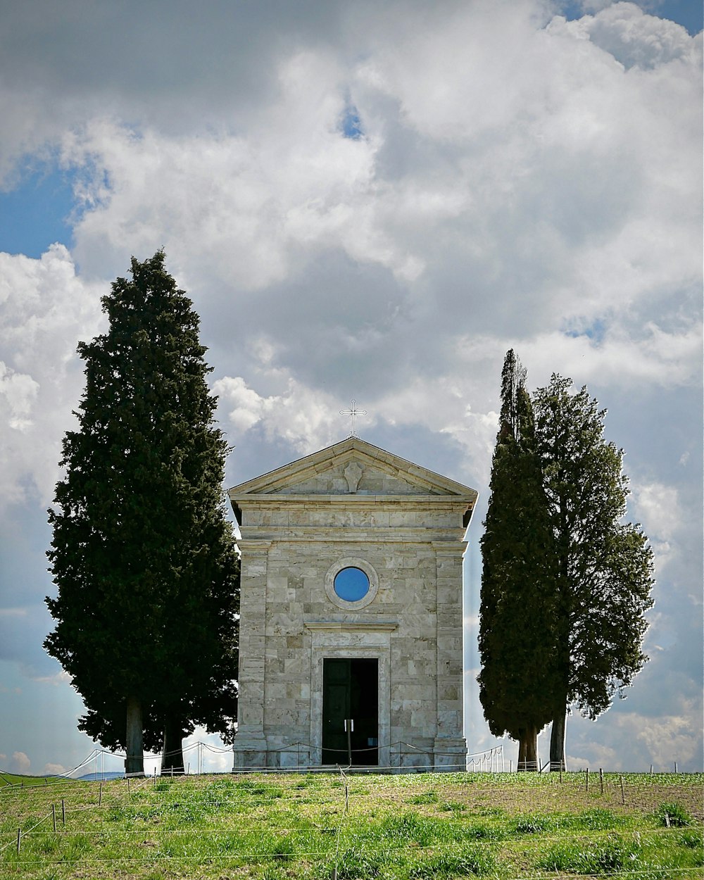 a small stone building with trees in front of it