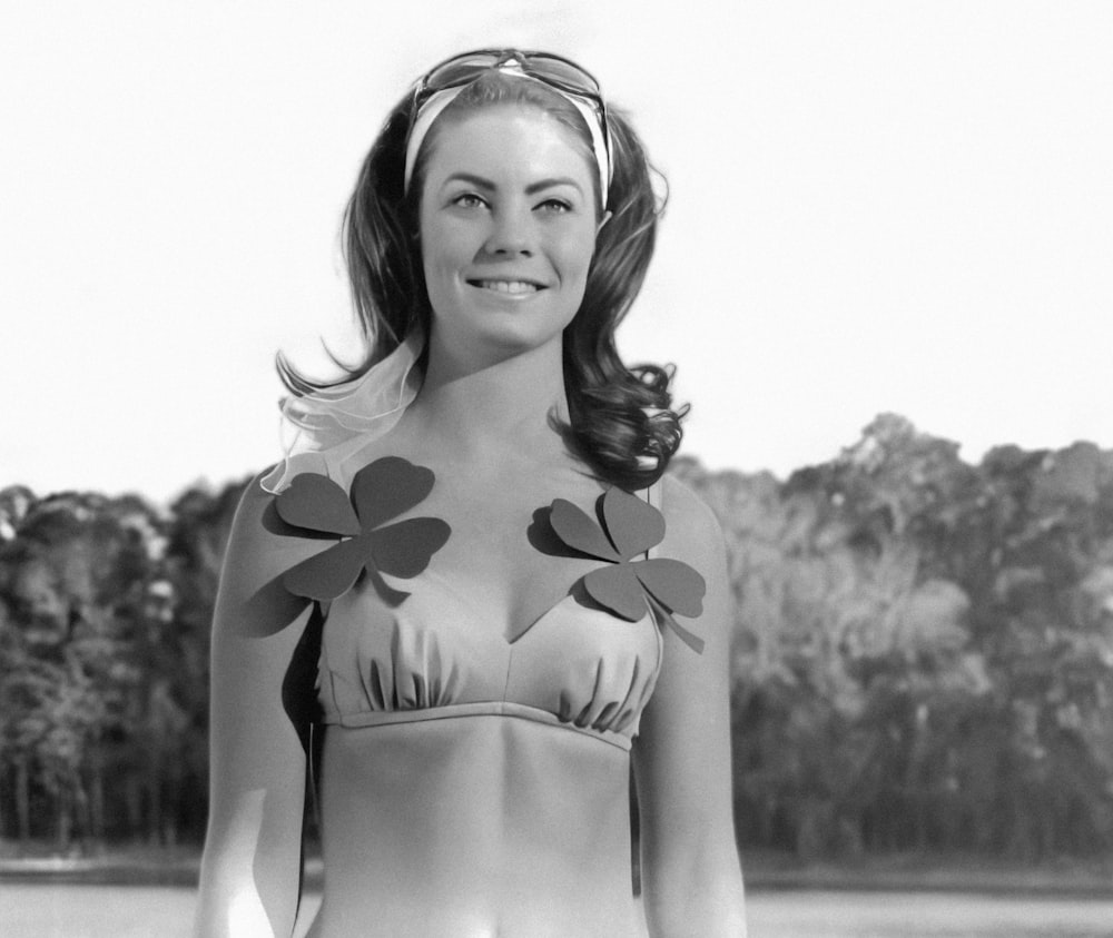 a woman in a bikini with four leaf clovers on her chest