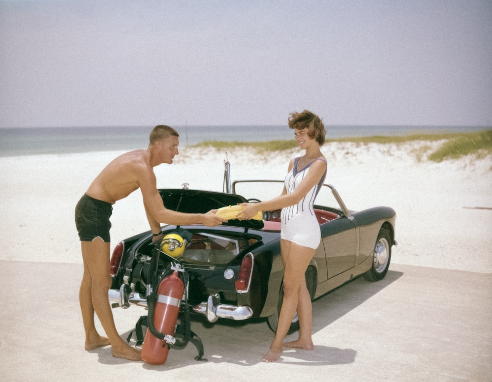 a man standing next to a woman near a car