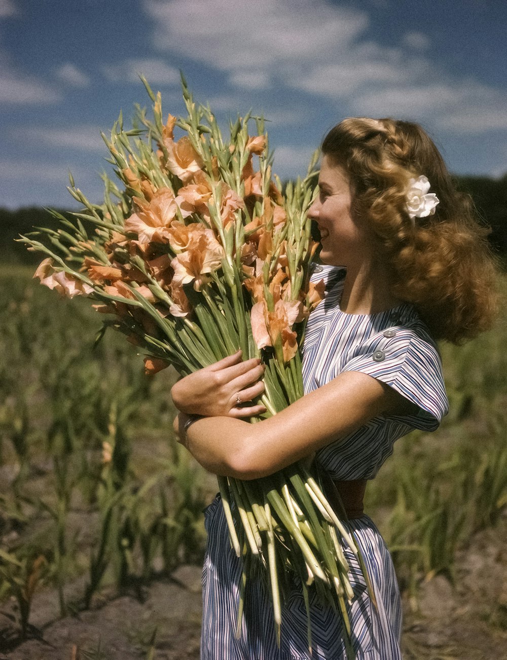 una donna che tiene un mazzo di fiori in un campo