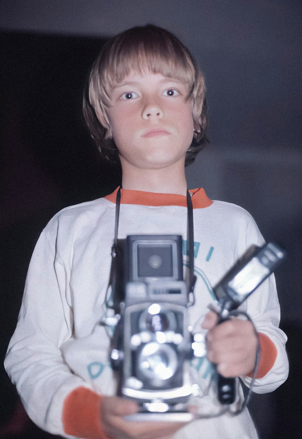a young boy holding a camera in his hands