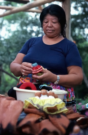A woman proudly displaying handmade crafts she created after completing training.