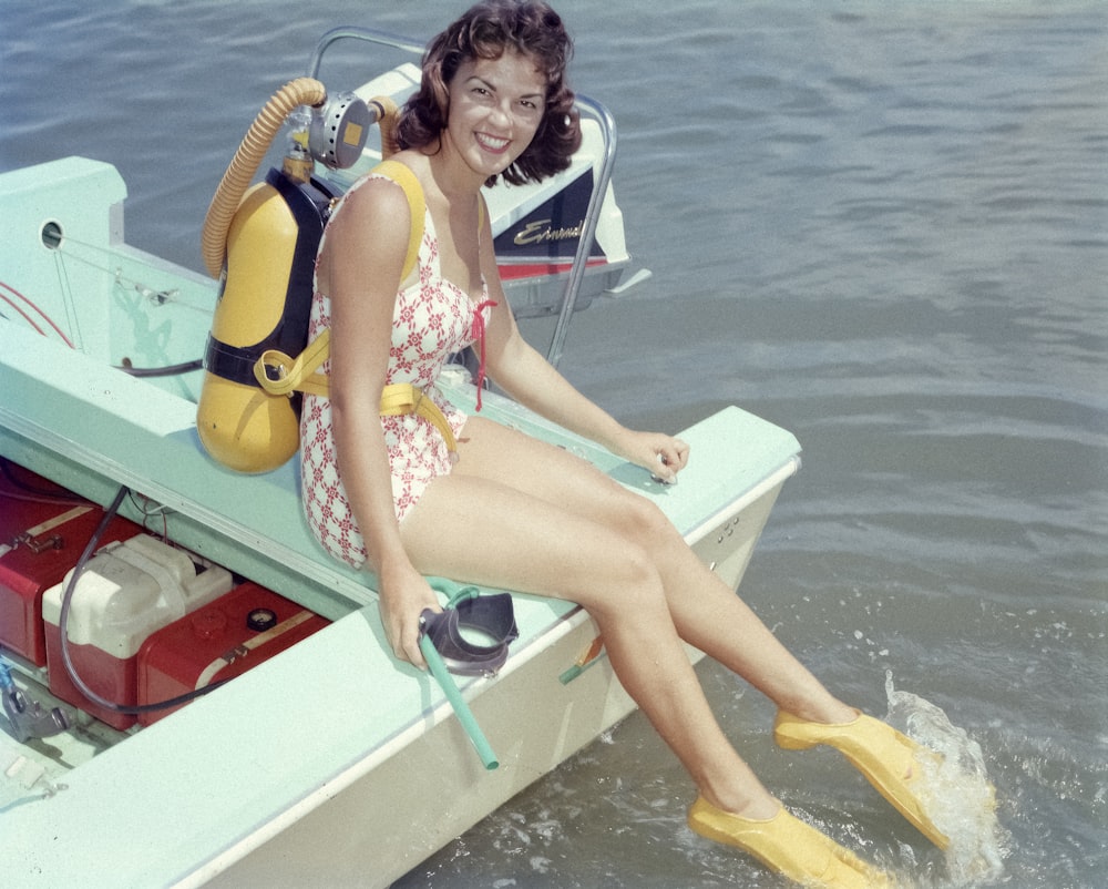 a woman in a bathing suit sitting on a boat