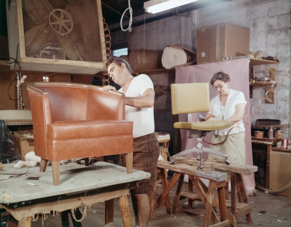 a man working on a leather chair in a shop