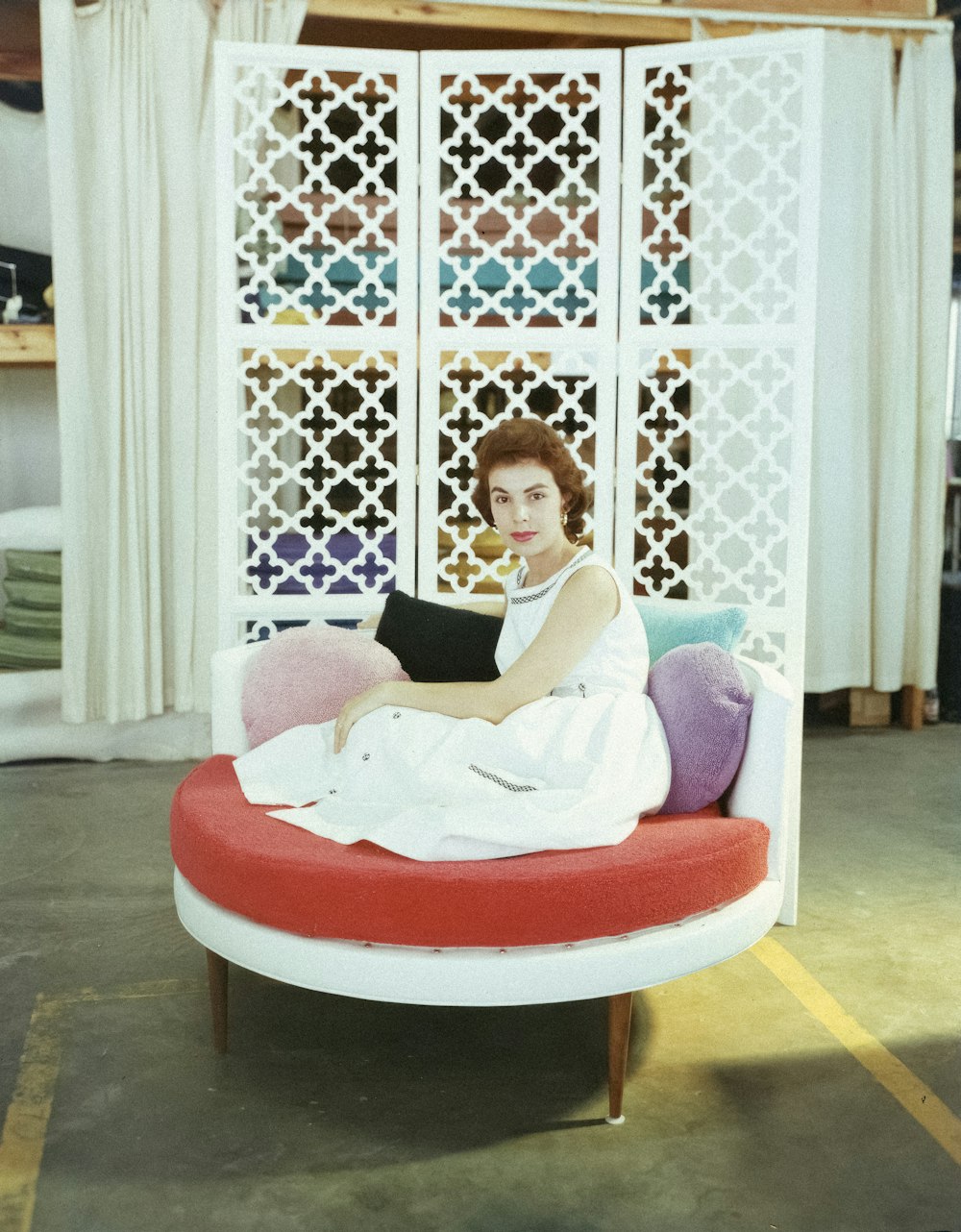 a woman sitting on top of a red and white couch