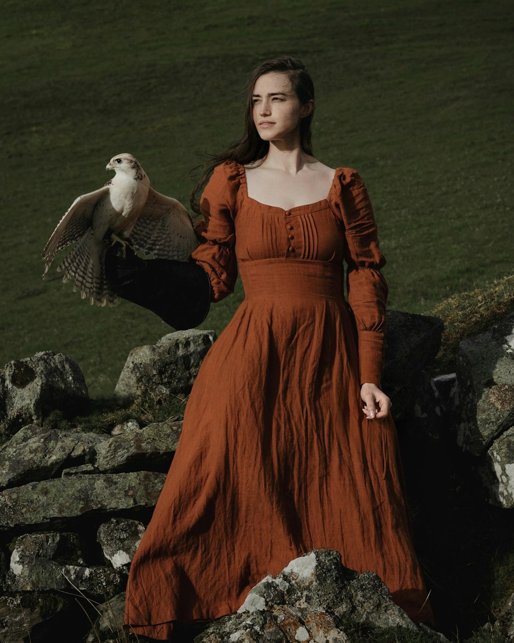 a woman in a red dress holding a bird