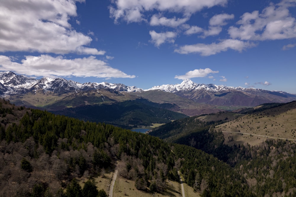 a scenic view of a mountain range with snow capped mountains in the distance