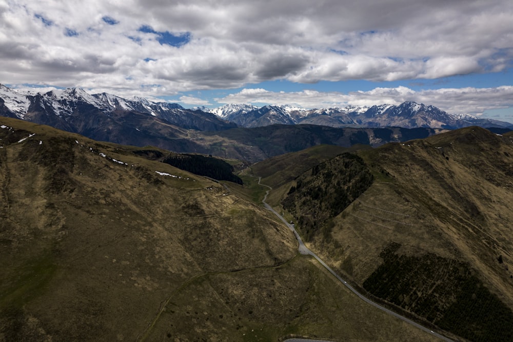 an aerial view of a road winding through the mountains