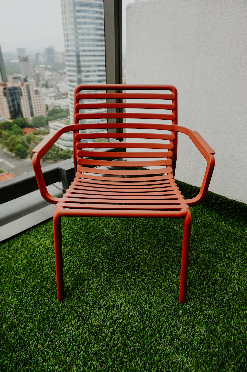a red chair sitting on top of a lush green field