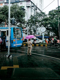 a man walking across a street holding an umbrella