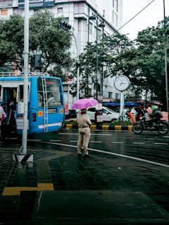 a man walking across a street holding an umbrella