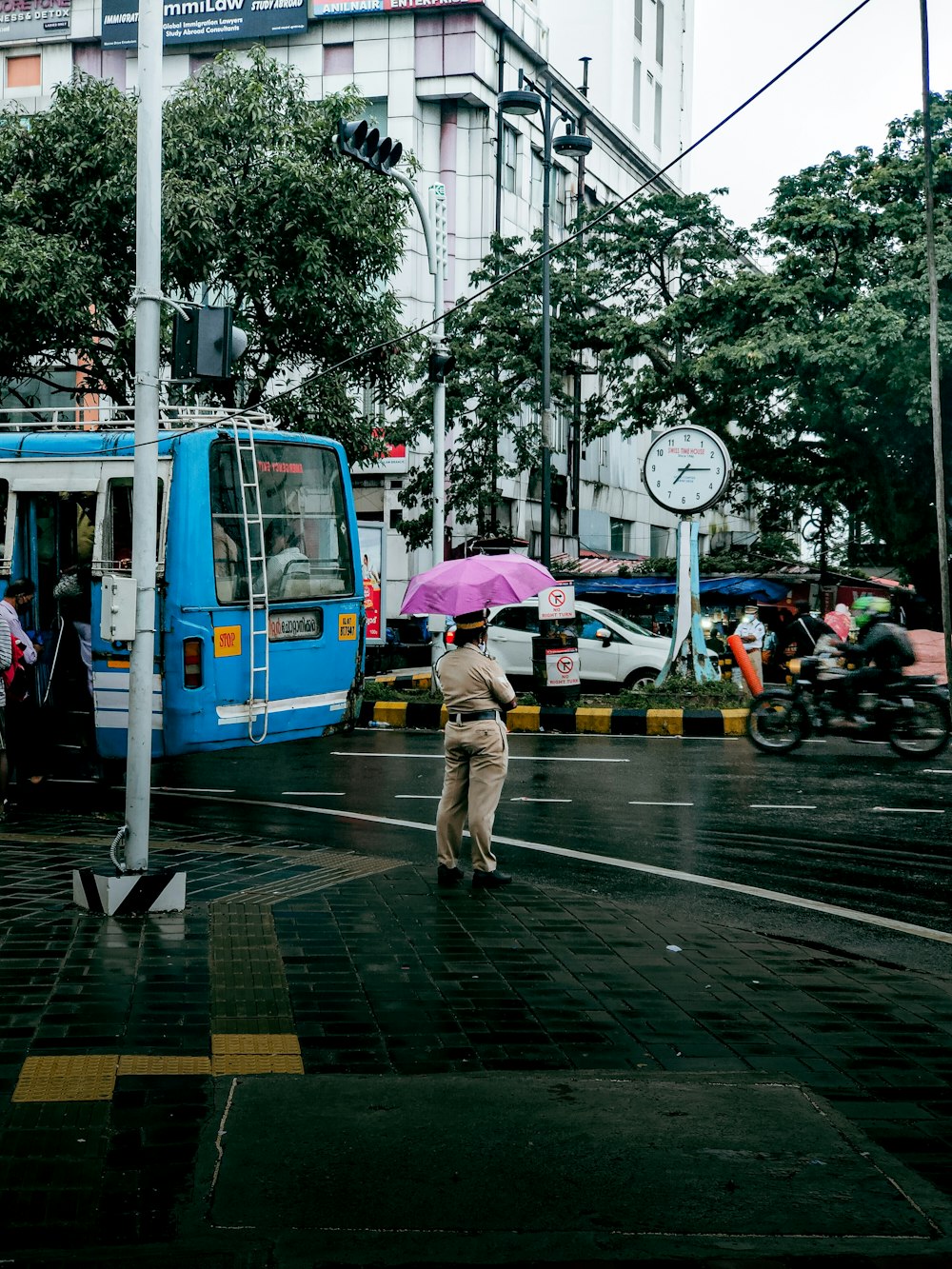 Un uomo che cammina attraverso una strada tenendo un ombrello