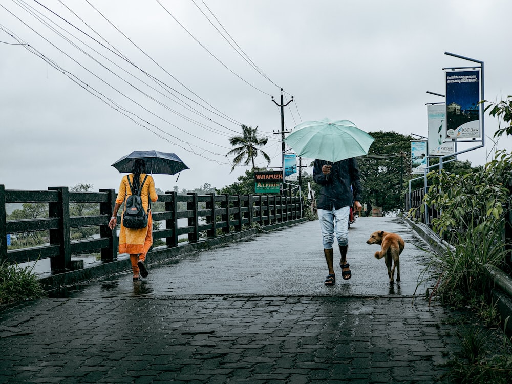 a man and a woman walking down a sidewalk with an umbrella