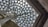 Geometric glass ceiling with triangular panes supported by metal beams, illuminating the space with natural light.