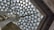 Geometric glass ceiling with triangular panes supported by metal beams, illuminating the space with natural light.