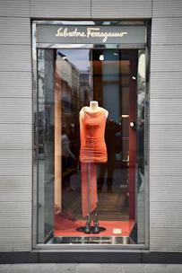 A fashionable women's dress showcased on a mannequin against a clean white wall with blue and orange highlights.