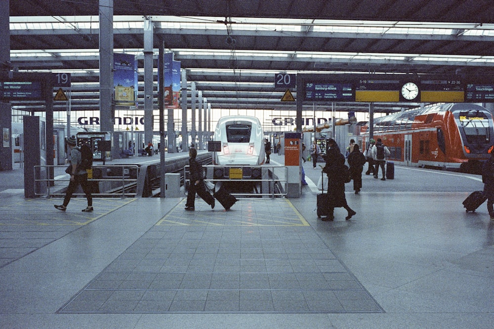 a group of people walking around a train station