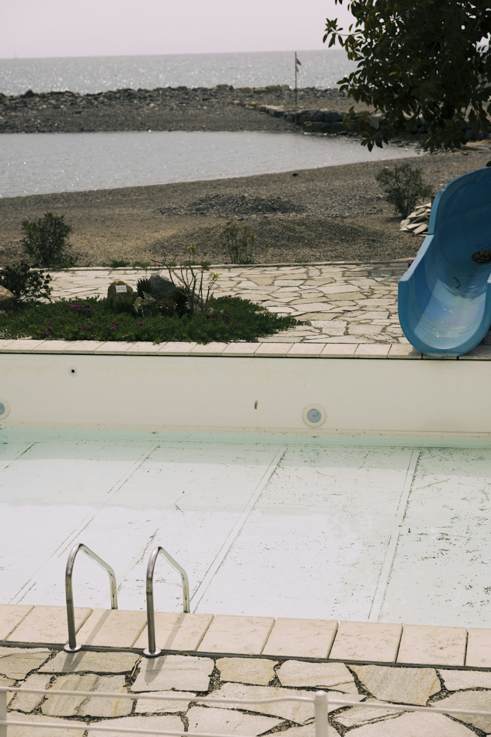 a swimming pool with a slide next to a body of water