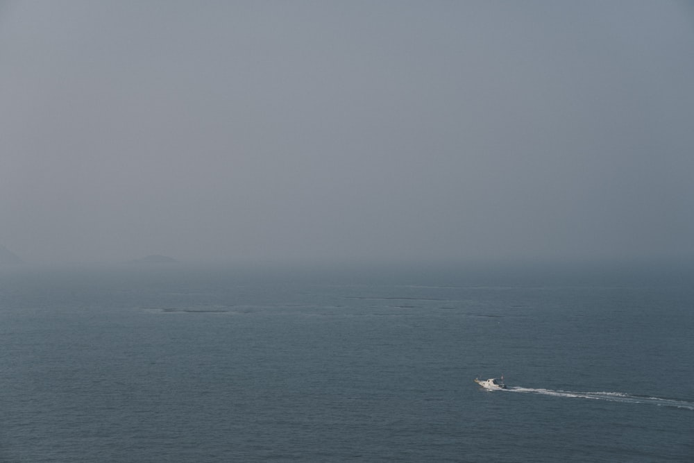 a boat in the ocean on a foggy day