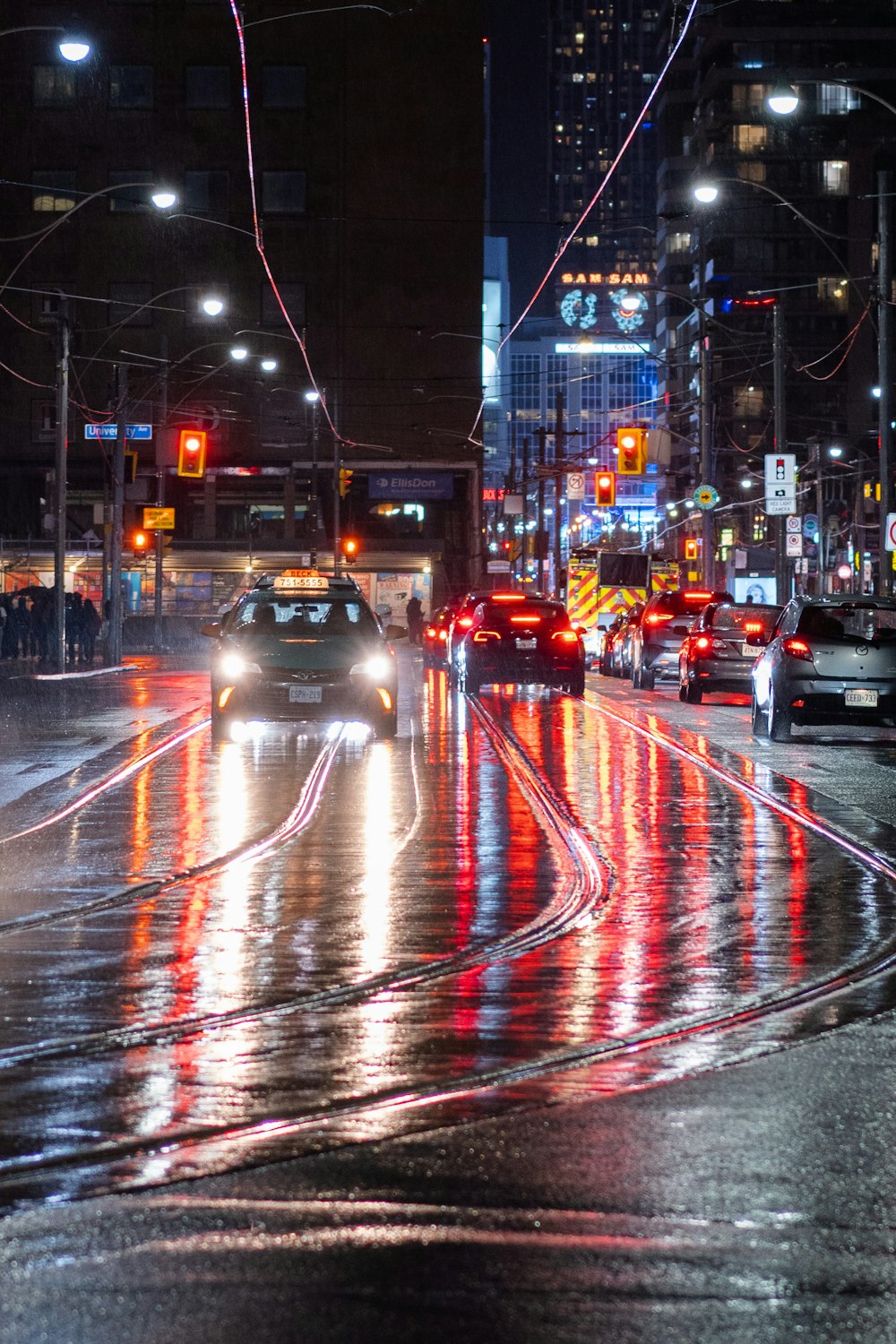 a busy city street at night with cars driving on it