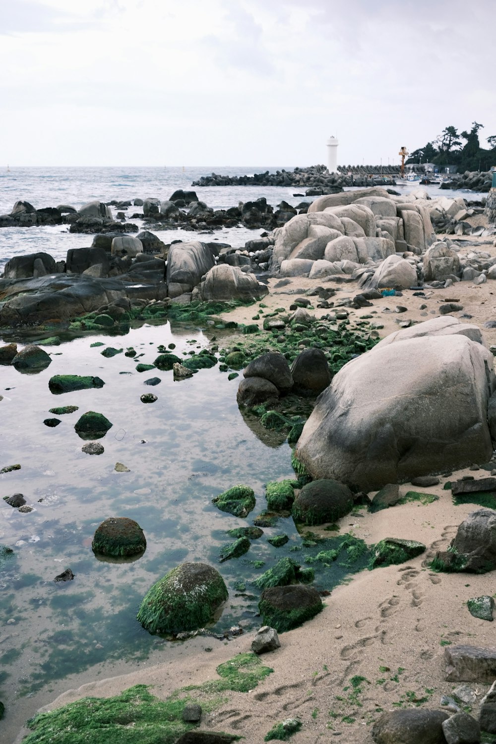 uma grande rocha sentada no topo de uma praia de areia