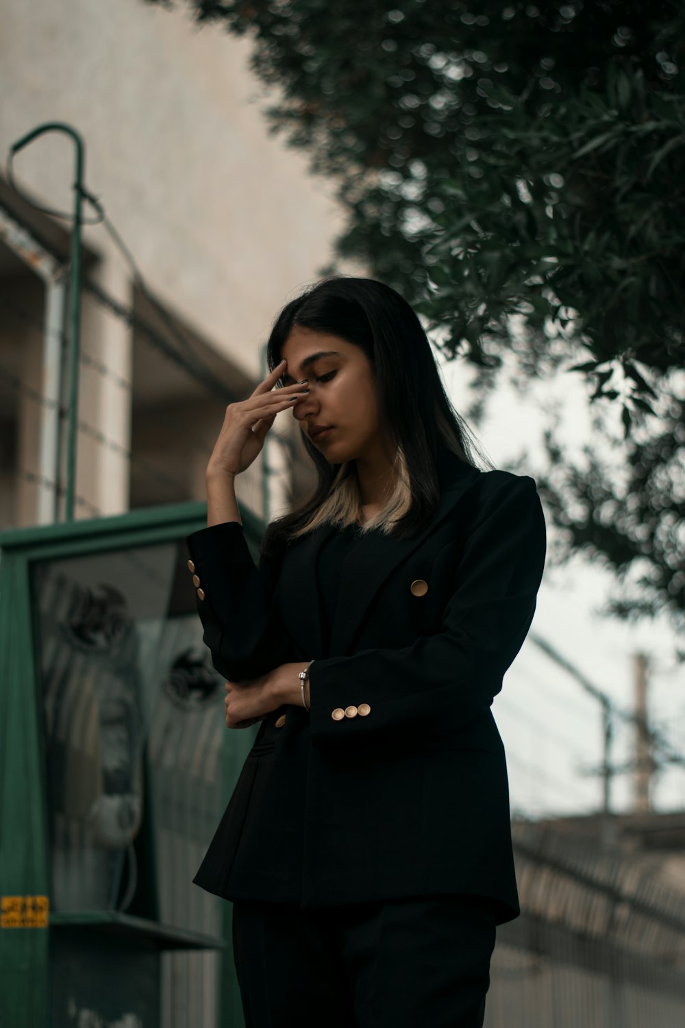 a woman in a black suit is talking on her cell phone