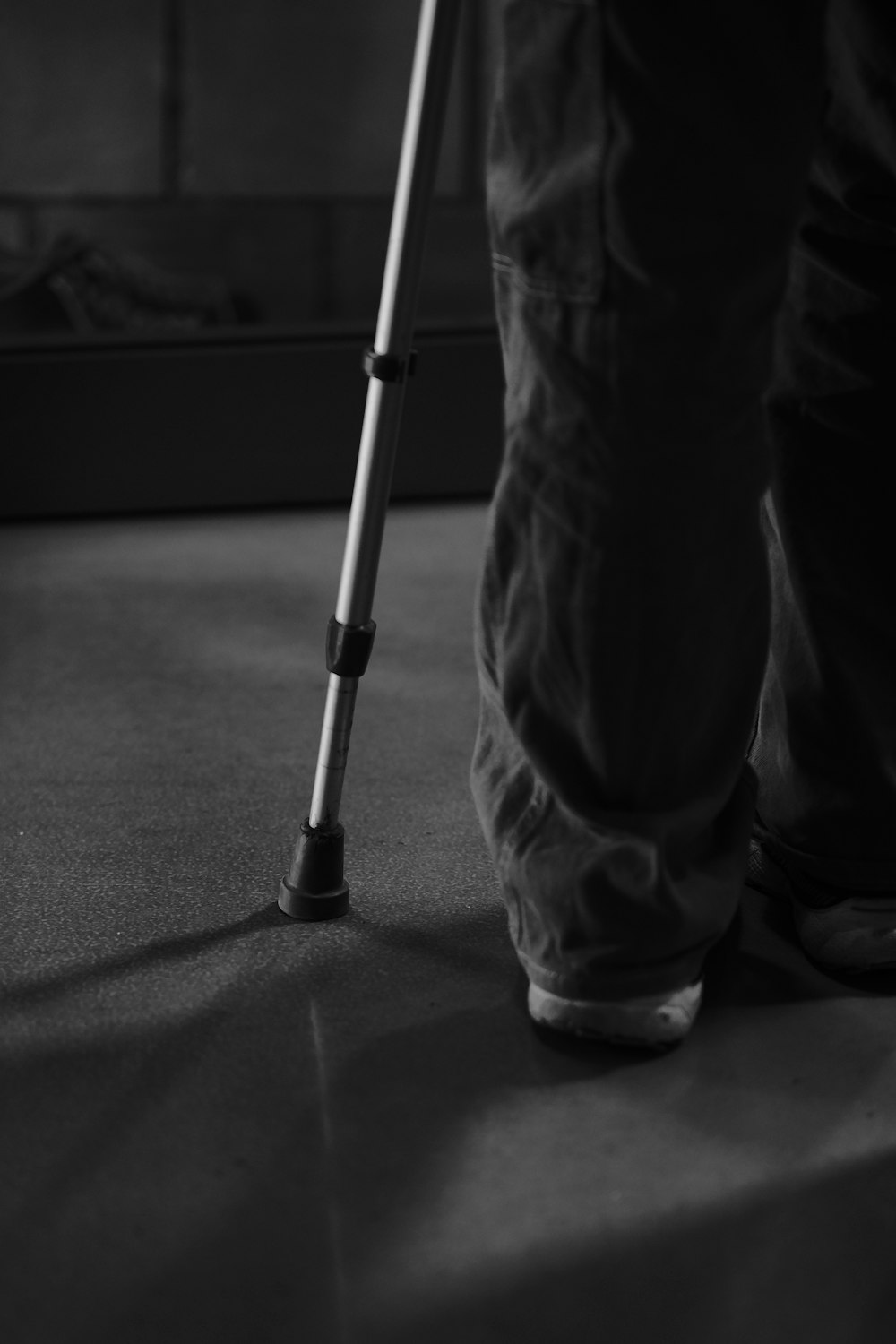 a black and white photo of a person with a crutch