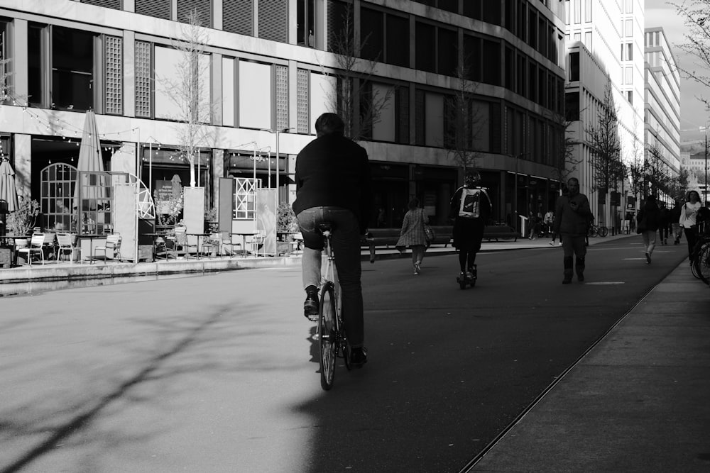 a man riding a skateboard down a street next to tall buildings