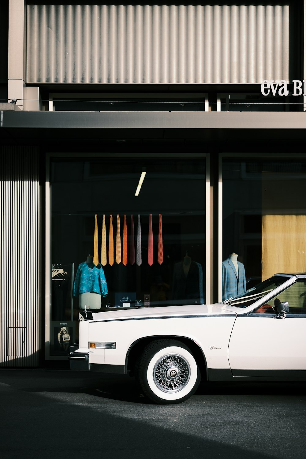 a white car parked in front of a store