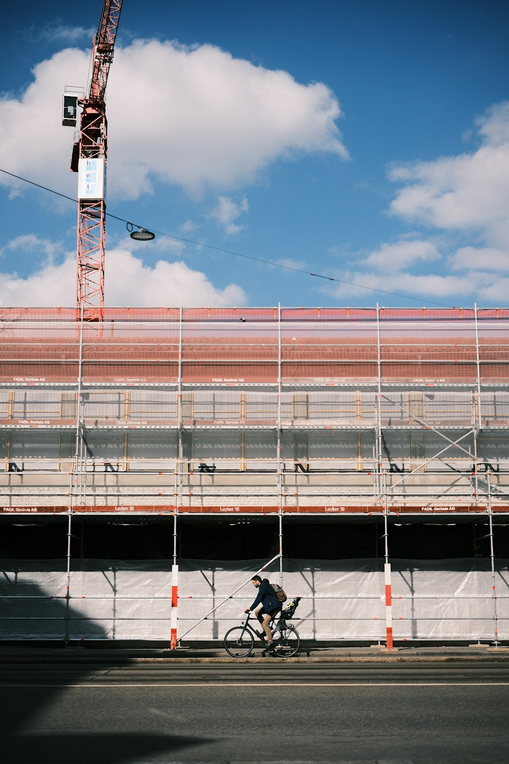 a man riding a bike down a street next to a tall building