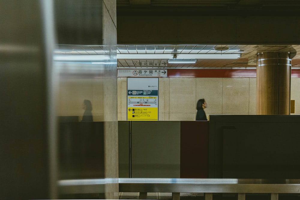 a woman standing at a counter in a train station