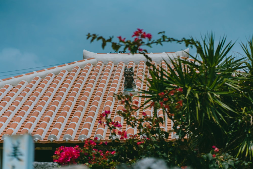 a tiled roof with pink flowers in the foreground