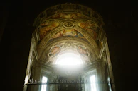 Detail of a restored ceiling with original frescoes and subtle lighting.