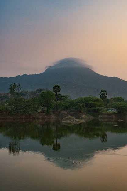 A serene mountain landscape painting bathed in soft light, capturing a contemplative atmosphere.