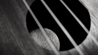 a black and white photo of an acoustic guitar