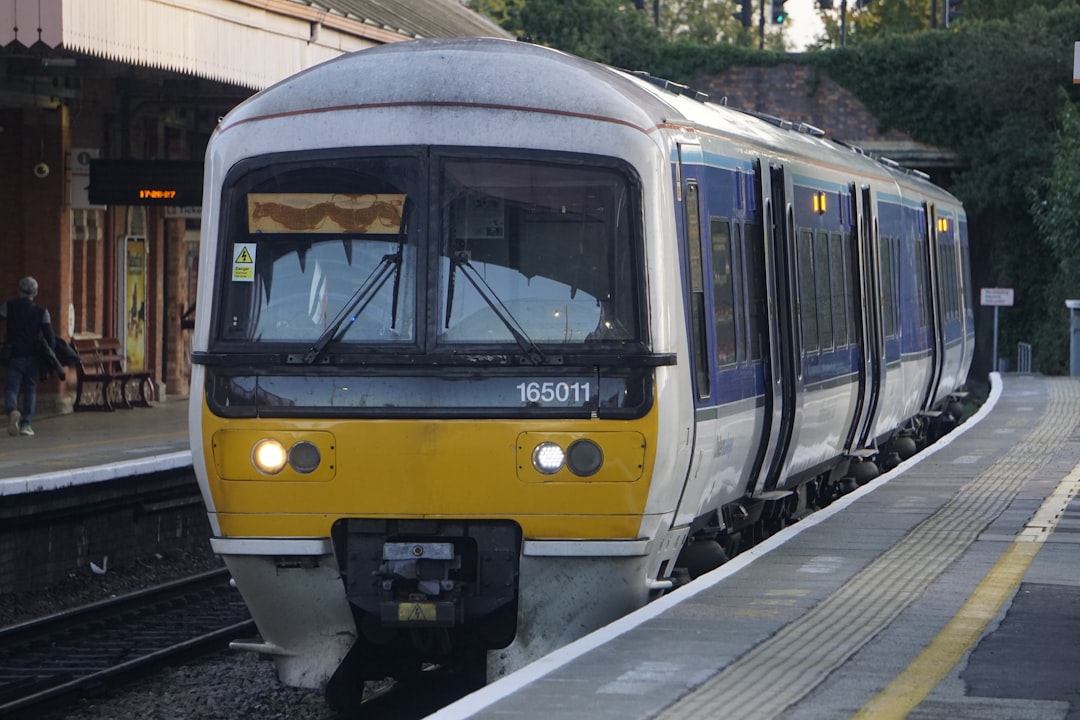 a yellow and white train pulling into a train station, A Class 165