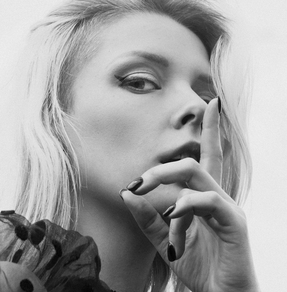 a black and white photo of a woman smoking a cigarette