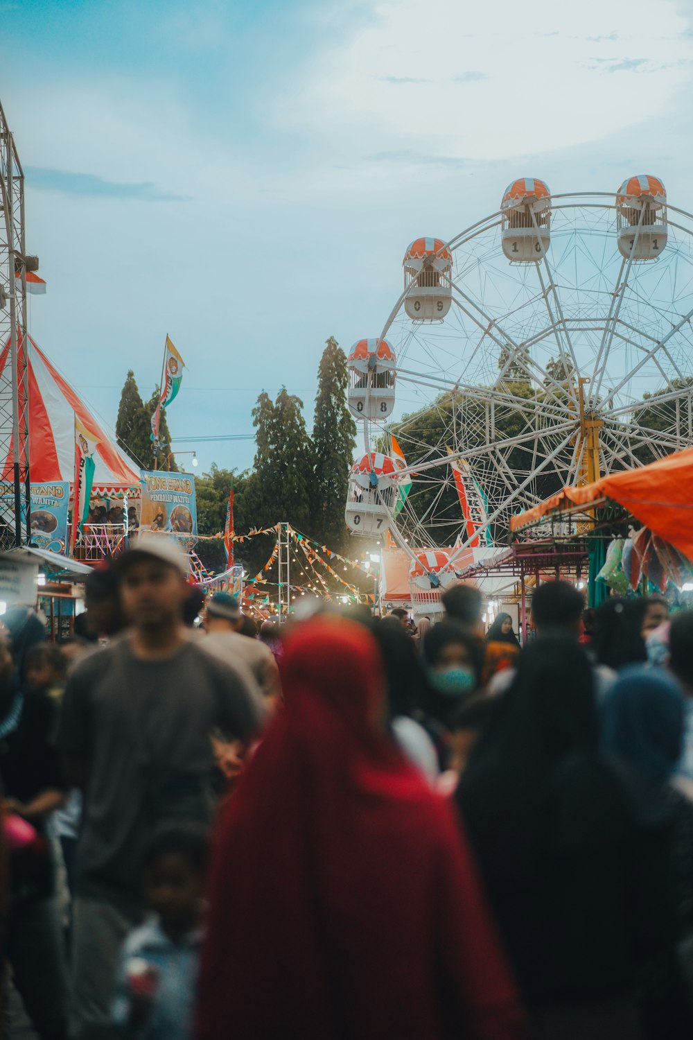 a crowd of people standing around a carnival