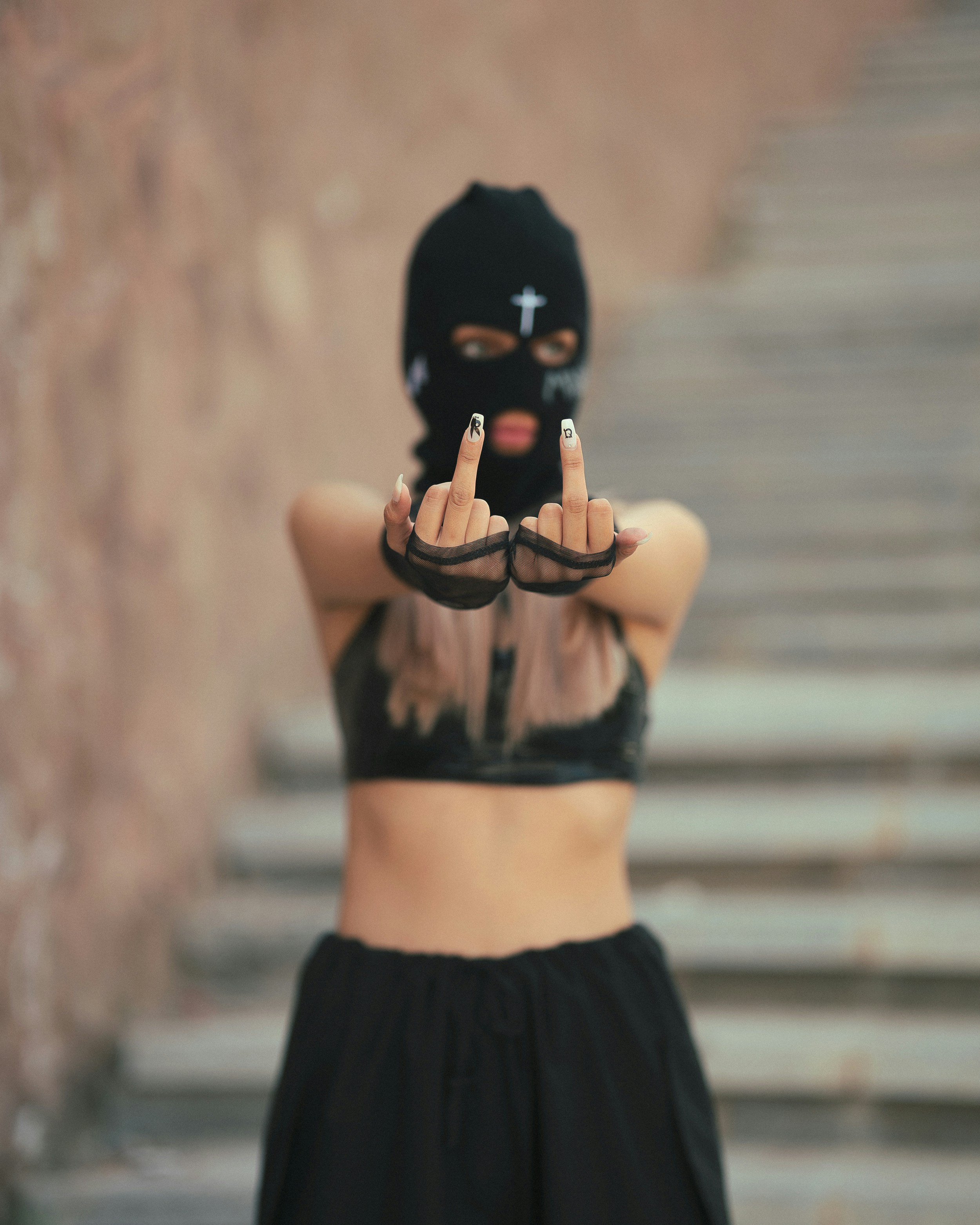 A woman wearing a black mask and black pants
