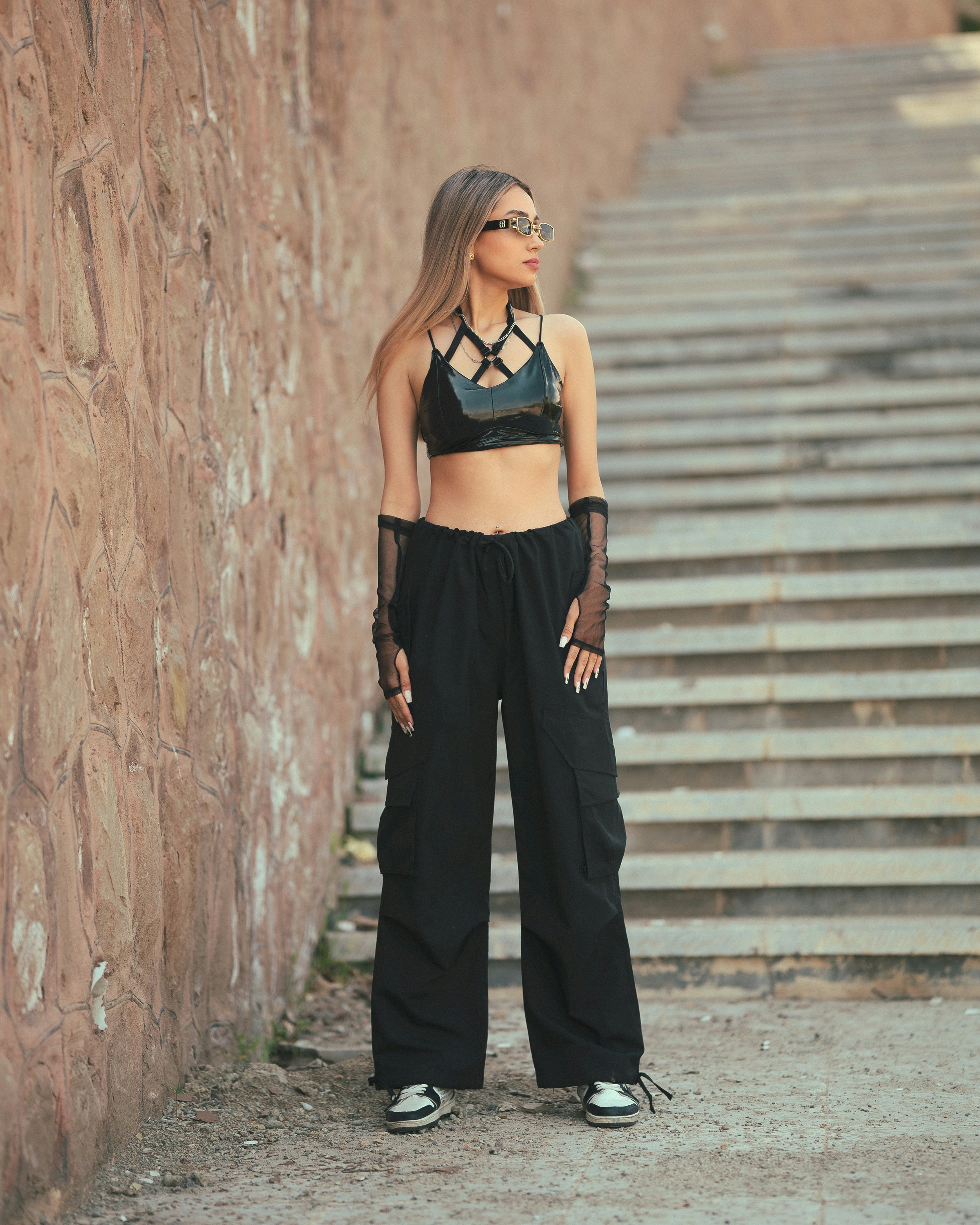 A woman standing in front of a stone wall