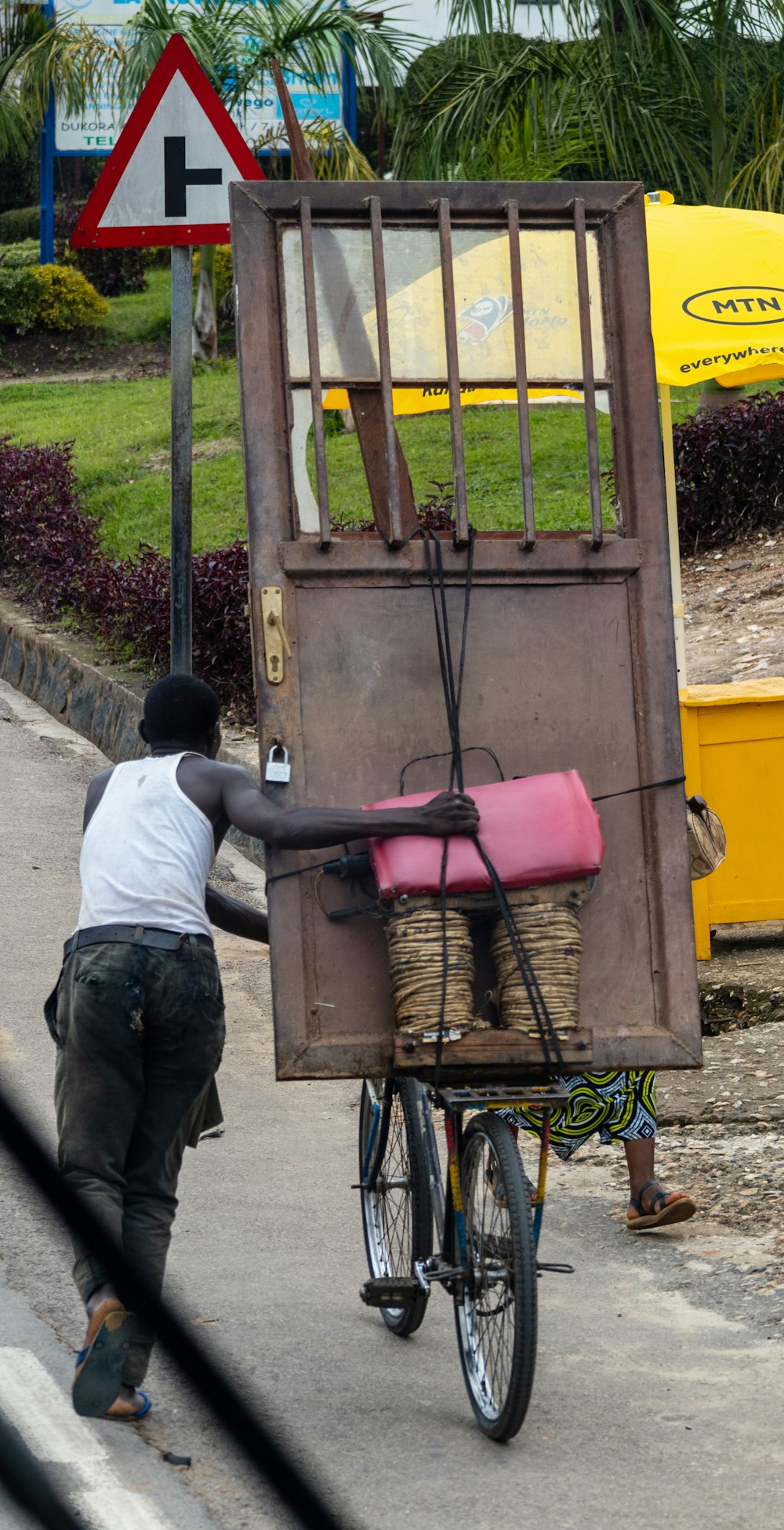 a man riding a bike with a cage on the back of it