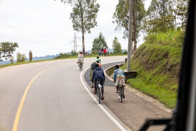 A scenic countryside view featuring a group on a bicycle tour along a winding path.