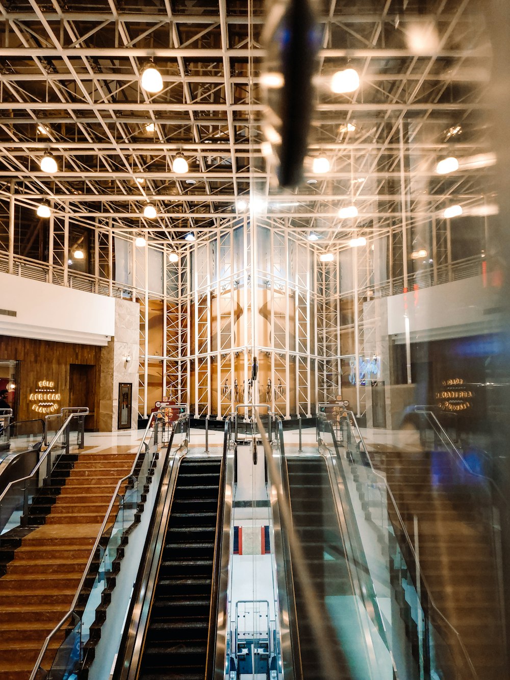 an escalator in a large building with lots of lights