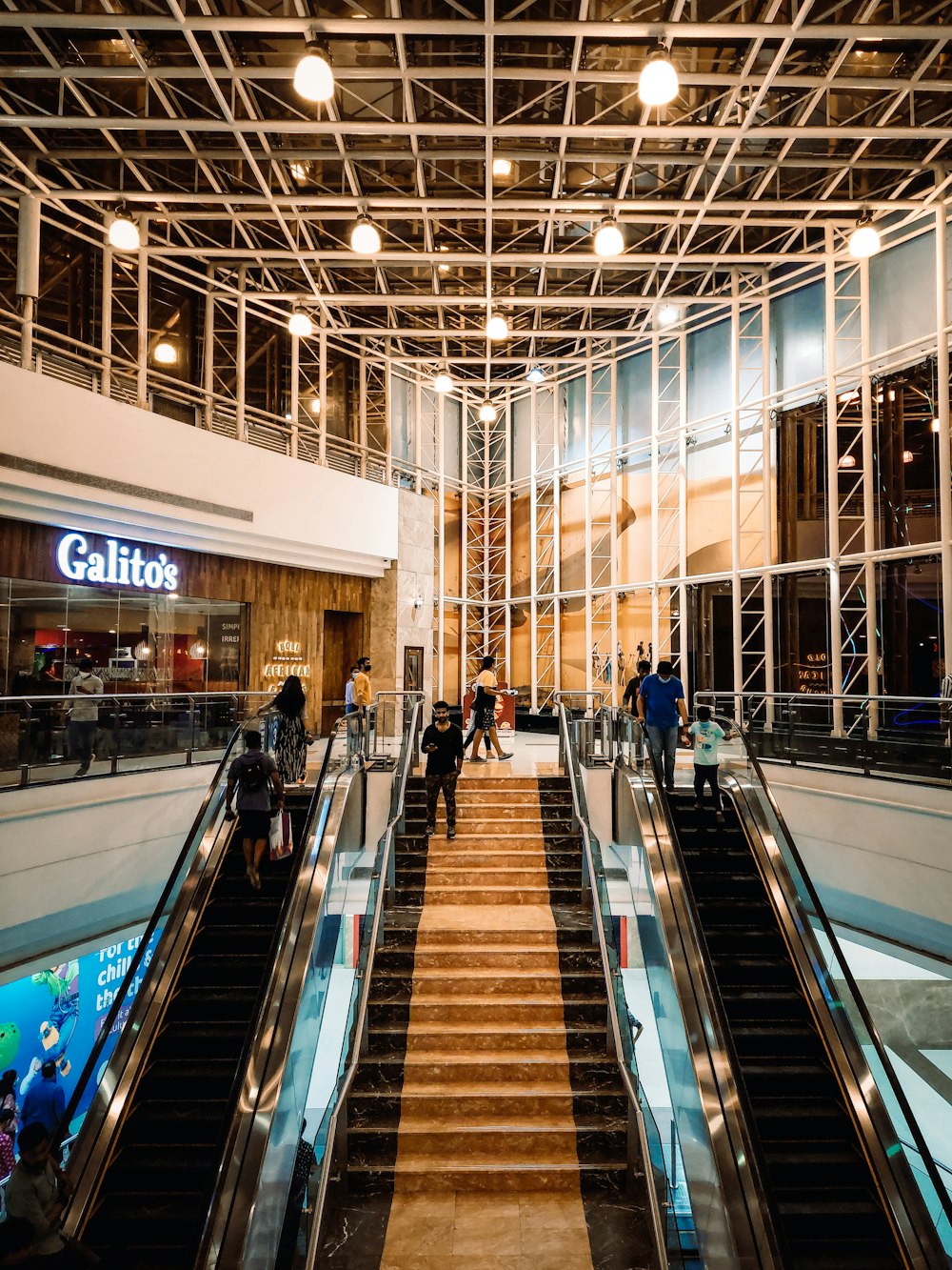 a group of people riding down an escalator in a building