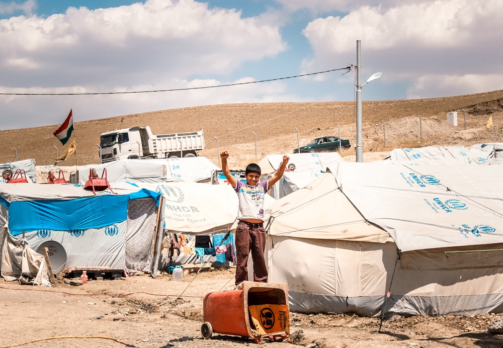 a man standing in front of a bunch of tents