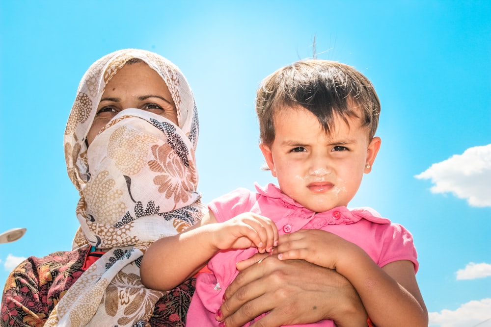 a woman holding a child in her arms