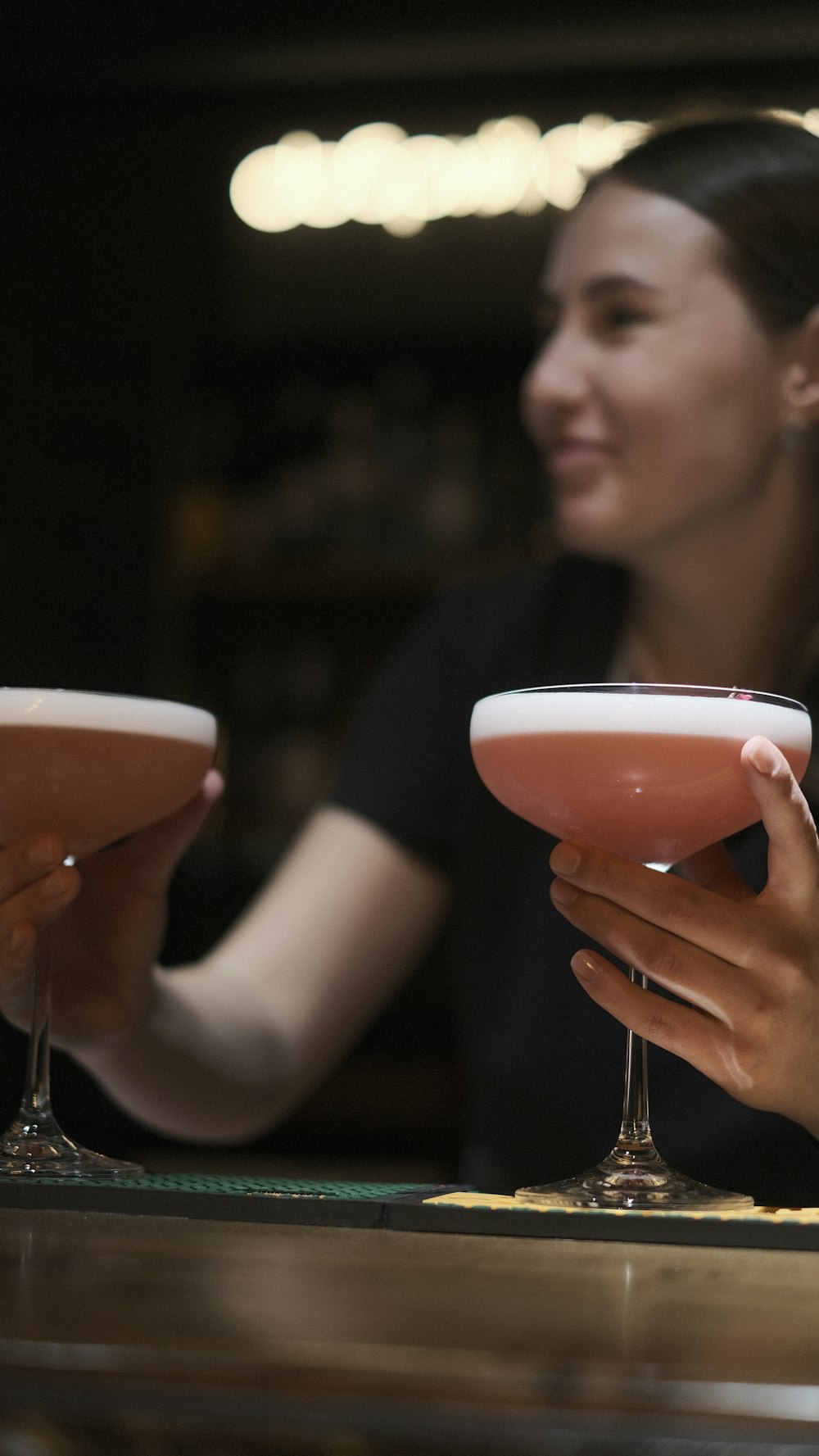 a woman sitting at a bar holding a drink