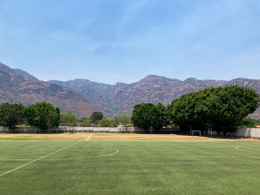 um campo de futebol com montanhas ao fundo