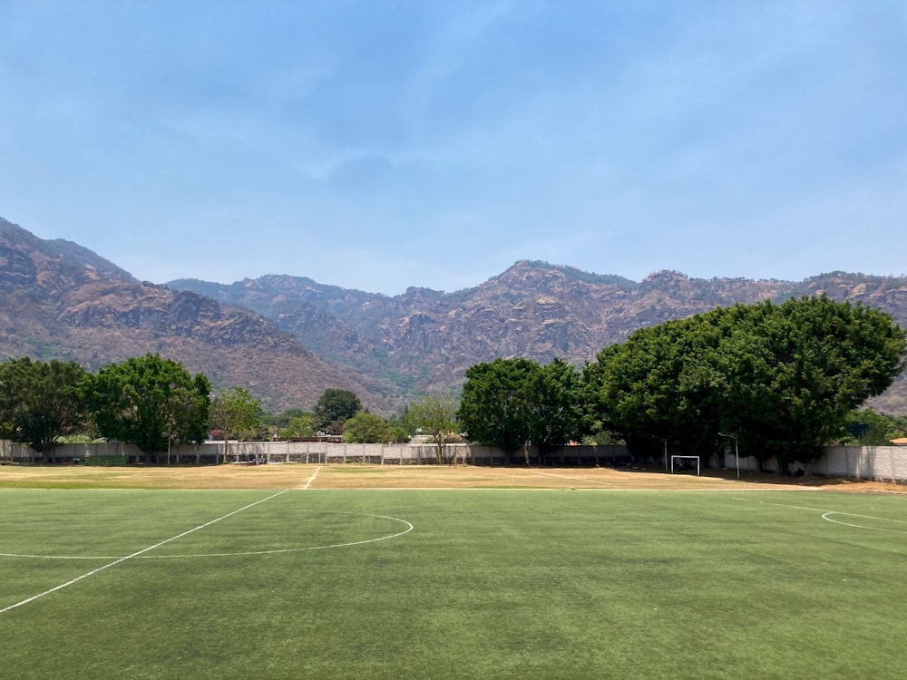 a soccer field with mountains in the background