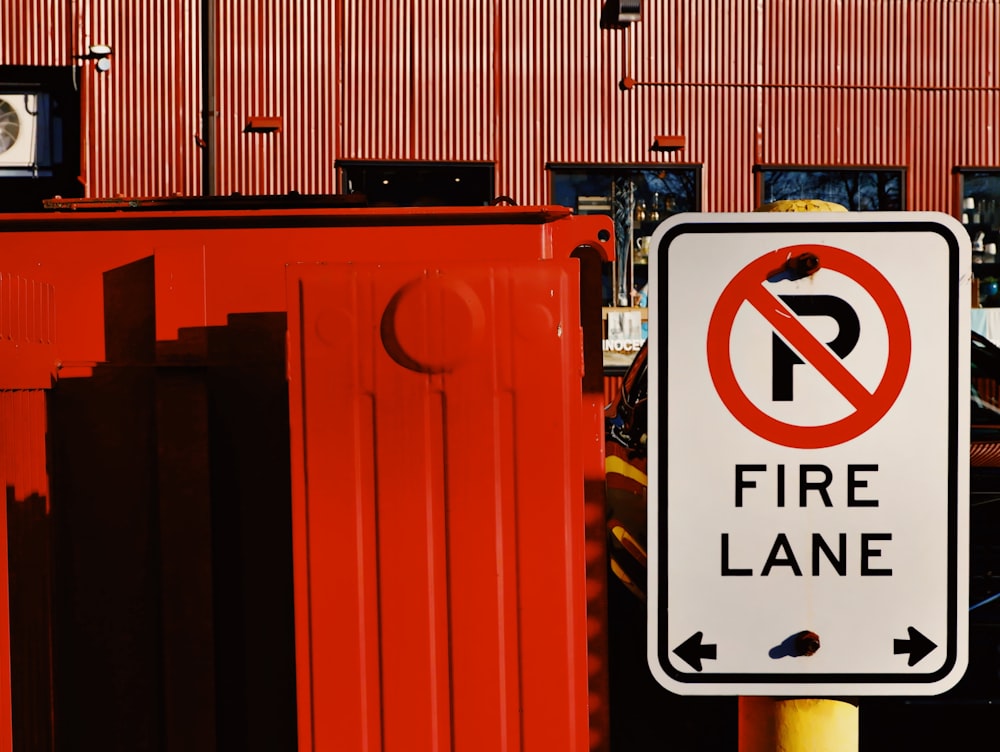 a no parking fire lane sign in front of a red building